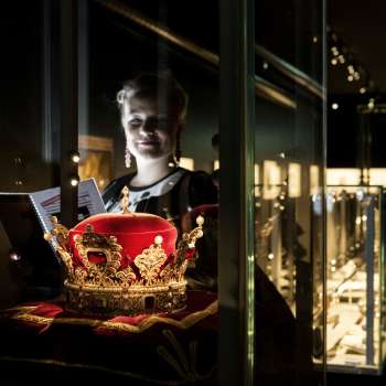 Une femme observe le chapeau princier exposé à la Chambre du Trésor du Liechtenstein