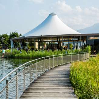 Steg au lac de baignade Grossabünt à Gamprin avec un pavillon moderne et une vue sur les montagnes en arrière-plan