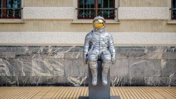 Sculpture d'astronaute en argent "Raumableiter" de Max Grüter devant le bâtiment du gouvernement à Vaduz - art moderne dans l'espace public.