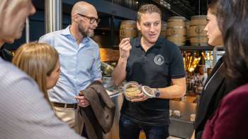 Un employé explique les ingrédients de la bière à un groupe de clients intéressés lors d'une visite guidée de la brasserie.