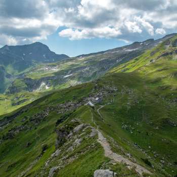 Vue panoramique sur le refuge Pfälzerhütte dans les Alpes liechtensteinoises avec une ambiance nuageuse dramatique.