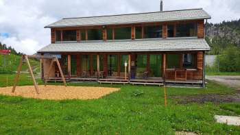 Photo extérieure du Malbipark-Bistro avec une aire de jeux et une prairie au premier plan