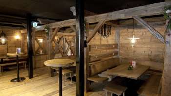 Un espace confortable avec des bancs et des tables en bois dans le style traditionnel du Malbuner Lädeli