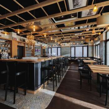 Intérieur lumineux du St. Martins Pub avec bar, mobilier en bois et grandes baies vitrées.