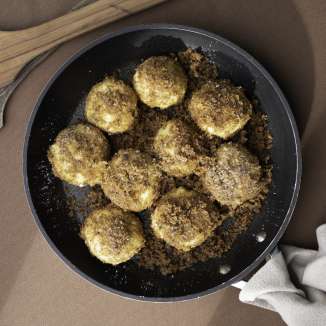 Quenelles de quetsches fraîchement frites dans des miettes de beurre - une pâtisserie du Liechtenstein servie à la poêle