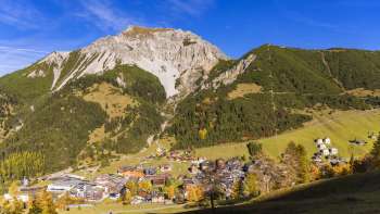 Vue sur le village de montagne de Malbun au Liechtenstein avec le paysage montagneux environnant par ciel dégagé.