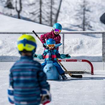 Famille faisant du patin à glace et du curling à Malbun