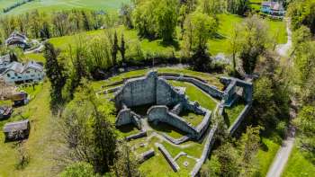 Vue aérienne des ruines du château de Schellenberg, entourées d'une forêt dense et de prairies