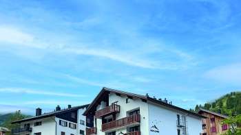 Vue extérieure du restaurant sous un autre angle, en mettant l'accent sur l'architecture rustique et le cadre pittoresque.