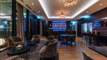 Bar confortable avec un éclairage élégant et une sélection de spiritueux.