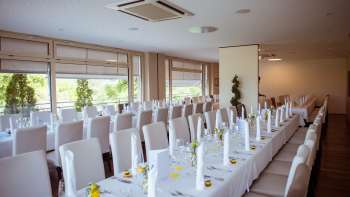 Salle solennellement décorée avec une disposition élégante des tables, des housses blanches et des détails raffinés