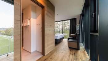 Chambre lumineuse à l'hôtel Kommod, dotée d'un élégant parquet et offrant une vue sur la verdure