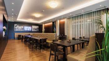 Salle élégante du restaurant Kommod avec une disposition symétrique et une atmosphère chaleureuse.