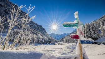 Des panneaux indicateurs enneigés et un paysage hivernal de rêve sous un soleil éclatant Steg , Liechtenstein.