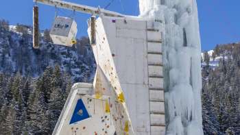 Tour de glace gelée à Malbun avec des voies d'escalade et des points d'ancrage visibles, contre un ciel bleu