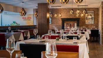 Restaurant élégant avec un mobilier de style, des nappes blanches et une cheminée pour une ambiance chaleureuse. Restaurant élégant avec un mobilier de style, des nappes blanches et une cheminée pour une ambiance chaleureuse.