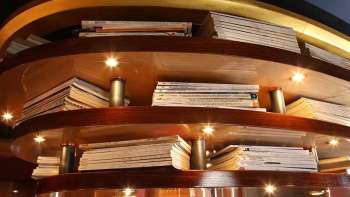 Étagère en bois avec des livres illuminés comme revêtement de plafond