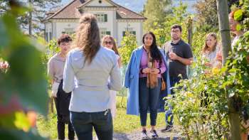 Visite guidée de la cave du Prince du Liechtenstein, où une femme informe le groupe sur le vin et la culture au milieu des vignes.