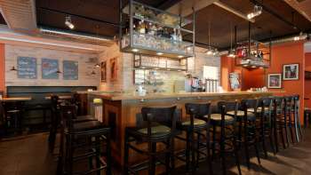 Intérieur stylé du bar du New Castle Vaduz avec un casier à bouteilles bien garni et un coin salon confortable.
