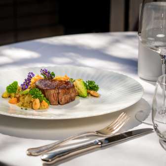 Plat de viande exquis avec légumes et fleurs au Park Hotel Sonnenhof sur la terrasse à Vaduz, Liechtenstein