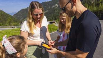 Une famille inscrit des points de minigolf sur une carte de score