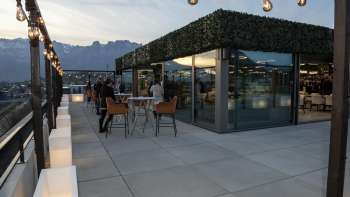 Terrasse du rooftop du restaurant Casino Royal avec vue sur le paysage montagneux environnant au crépuscule