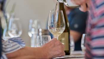 Un verre de vin blanc est versé pendant une dégustation guidée.