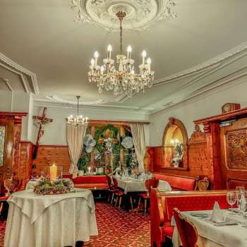 Détail d'un lustre au-dessus de tables festives dressées dans une ambiance rustique
