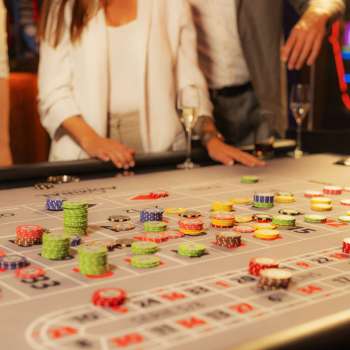 Des clients à la table de jeu en train de placer leurs jetons au casino Admiral Triesen, entourés d'une atmosphère de casino passionnante.