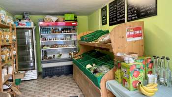  Salle de vente dans le magasin de la ferme Aeulehof avec légumes frais, boissons et étagères réfrigérées au Liechtenstein.