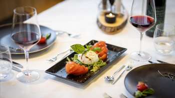 Une autre vue de la table dressée, avec un focus sur les assiettes noires modernes et les plats au centre.