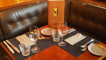 Table dressée avec menu dans le coin salon en cuir du Vanini Café