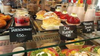 Large choix de gâteaux, tartes et snacks frais dans la vitrine du café 44 Café im Hof