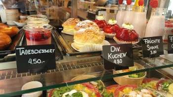 Large choix de gâteaux, tartes et snacks frais dans la vitrine du café 44 Café im Hof