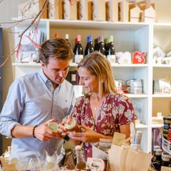 Un couple découvre des spécialités régionales dans la Hoi-Laden à Vaduz - découvrir de près des produits authentiques du Liechtenstein.