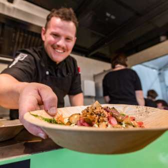 Un cuisinier sert une assiette avec un plat régional au festival du goût de Vaduz, Liechtenstein - un événement culinaire axé sur le goût
