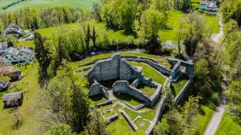 Vue aérienne des ruines du château de Schellenberg, entourées d'une forêt dense et de prairies