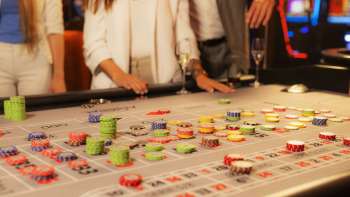 Des clients à la table de jeu en train de placer leurs jetons au casino Admiral Triesen, entourés d'une atmosphère de casino passionnante.