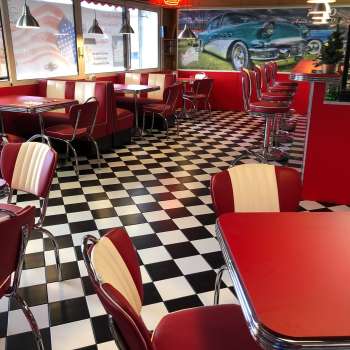 Intérieur du 1950 American Diner avec des tables rouges et un sol noir et blanc