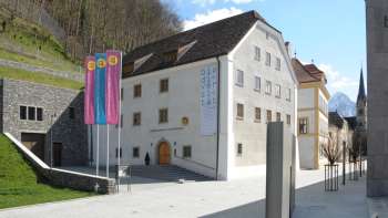 Vue extérieure du musée national du Liechtenstein avec les drapeaux au premier plan