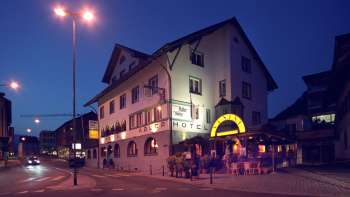 Vue extérieure du restaurant Adler le soir, avec une façade traditionnelle et un éclairage d'ambiance
