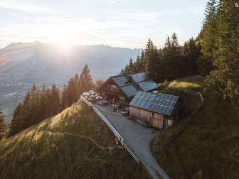 Photo panoramique d'un refuge de montagne isolé au Liechtenstein avec vue sur la vallée du Rhin et technologie solaire sur le toit