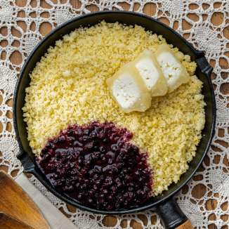 Rebel (Ribe) dans une poêle avec du beurre fondu et des airelles rouges, servi sur une nappe au crochet - plat typique du Liechtenstein