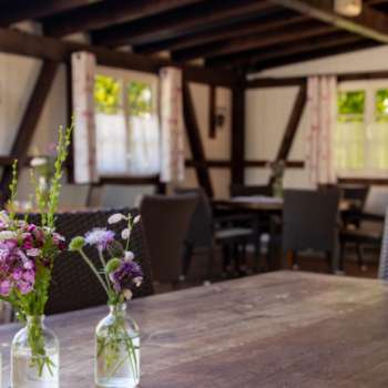 Terrasse confortable avec des meubles en bois et des décorations florales dans des bocaux