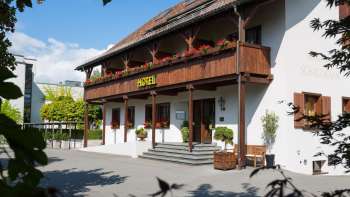 Vue extérieure du restaurant Vivid avec une façade traditionnelle, un balcon en bois et des jardinières fleuries