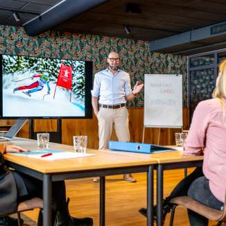 Salle de conférence moderne avec des participants à une réunion d'affaires, présentation sur le ski au Liechtenstein à l'écran