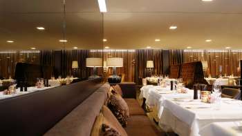 Restaurant élégant avec des tables recouvertes de miroirs et un éclairage tamisé