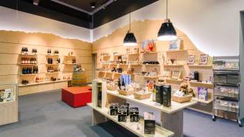  Centre d'accueil lumineux avec des étagères en bois modernes, remplies de souvenirs, de spécialités et de matériel d'information