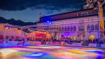 Vaduz on Ice - Expérience de patinage hivernal au cœur du Liechtenstein Patinoire colorée à Vaduz on Ice avec spectacle de lumières et patineuse devant le bâtiment du gouvernement au Liechtenstein