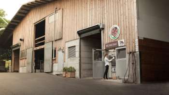 Vue extérieure du Kaiserhof au Liechtenstein avec station de lait en libre-service – régionale, fraîche et directement de la ferme.